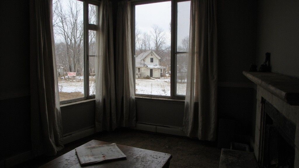 Abandoned house viewed through dusty window